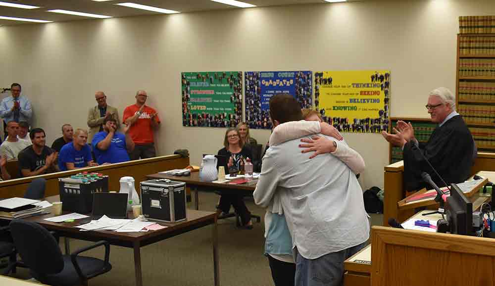 courtroom people hug family judge clap